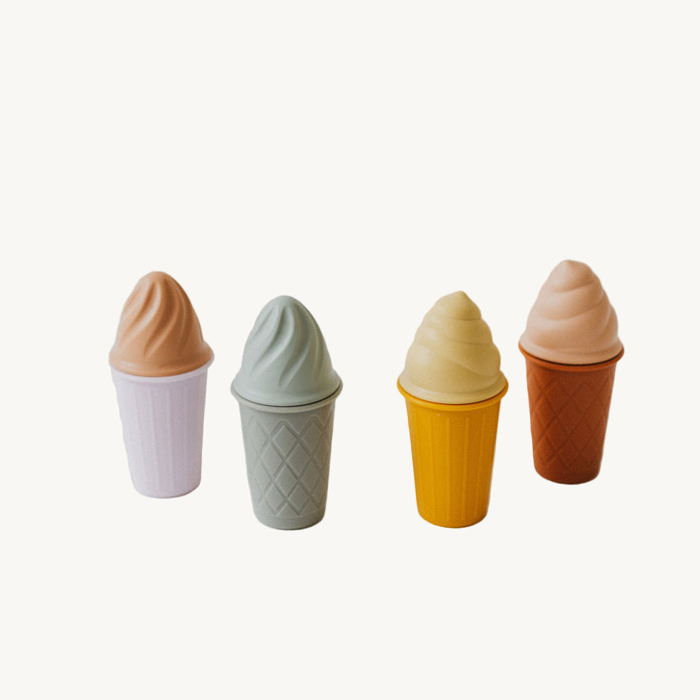 Four ice cream cones with different colored tops on a white background