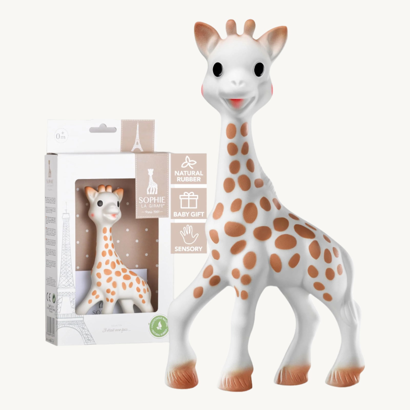 A plastic teething toy resembling a giraffe, predominantly white with brown spots, packaged in a box with a clear plastic window showing the product. Sophie le Giraffe