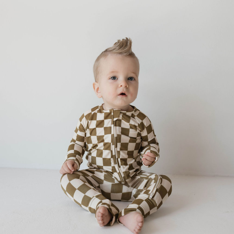 Baby wearing a checkered onesie on a white background