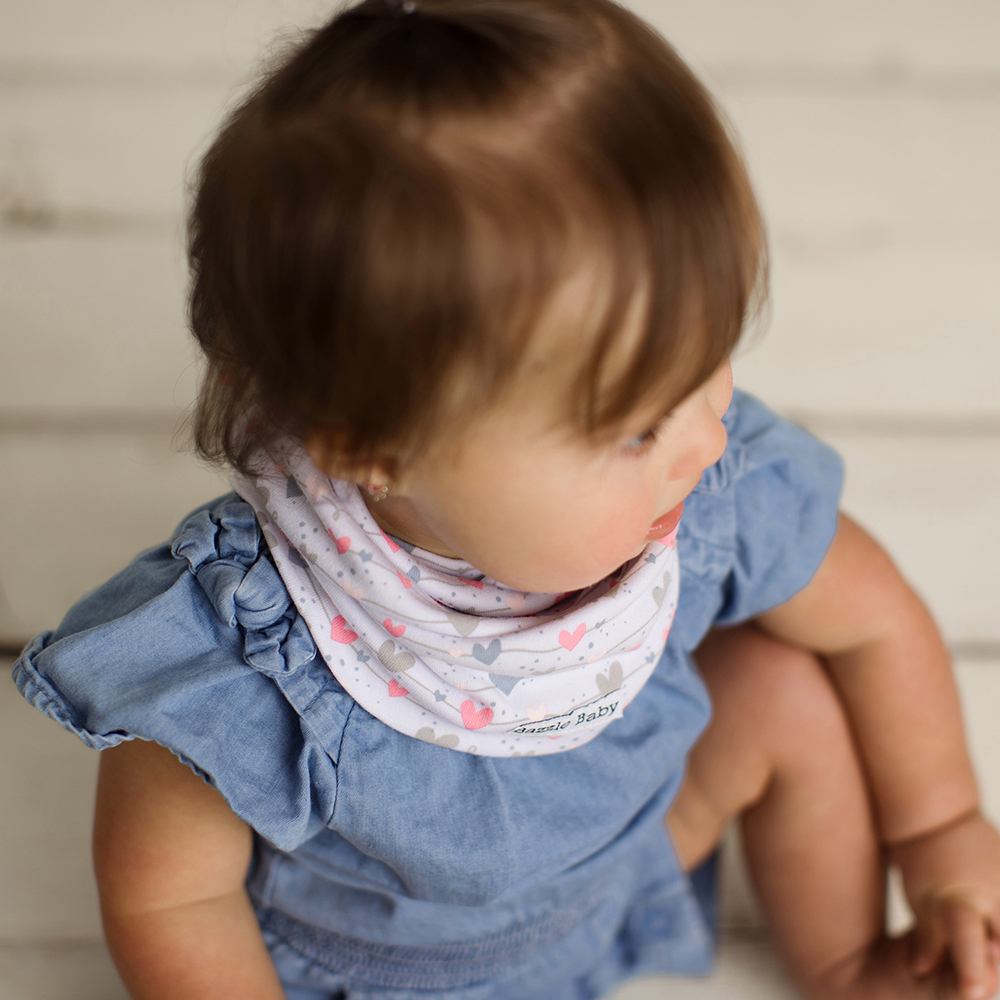 Baby wearing infinity scarf drool bib in wavy hearts and lines.