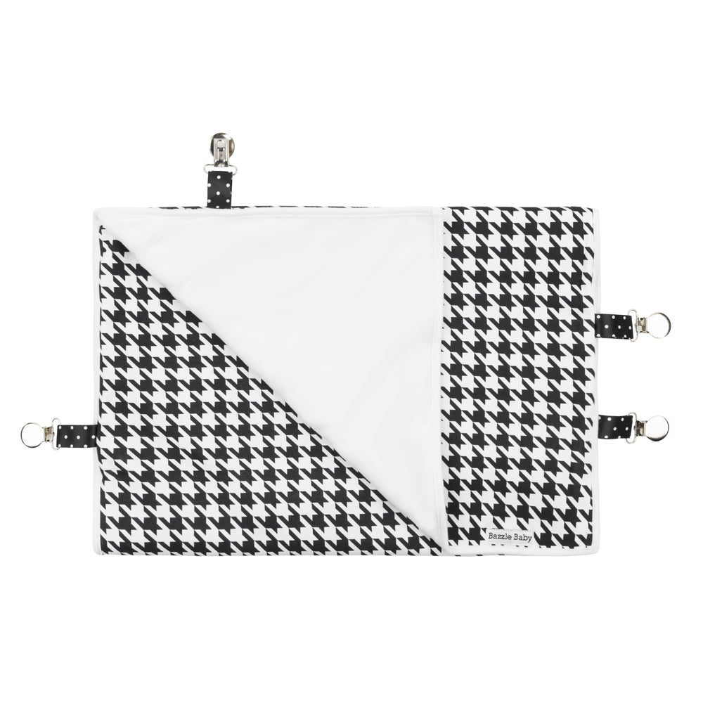 Black and white houndstooth Bazzlebaby GoBlanket. Features clips on the sides of the blanket to ensure it stays put on the car seat, stroller or clothing. Cotton front and fleece back.