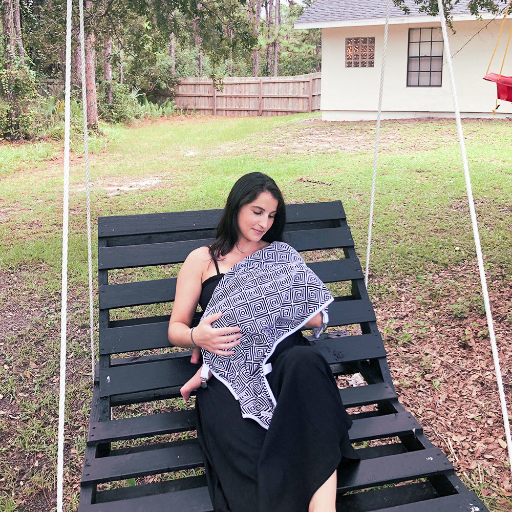 Black and white travel stroller blanket with clips and fuzzy fleece back.