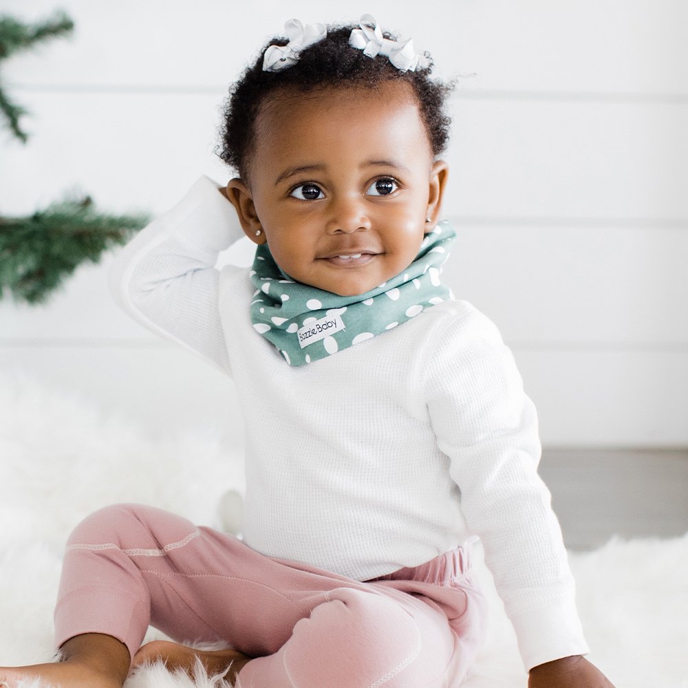 Baby wearing infinity scarf drool bib in green dots.
