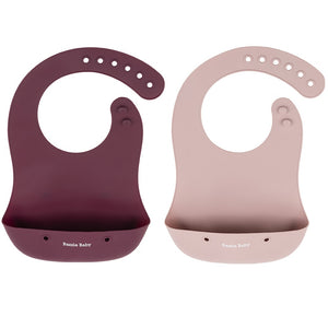 2 - pack of silicone baby bibs with food catching pocket in pink and cranberry.